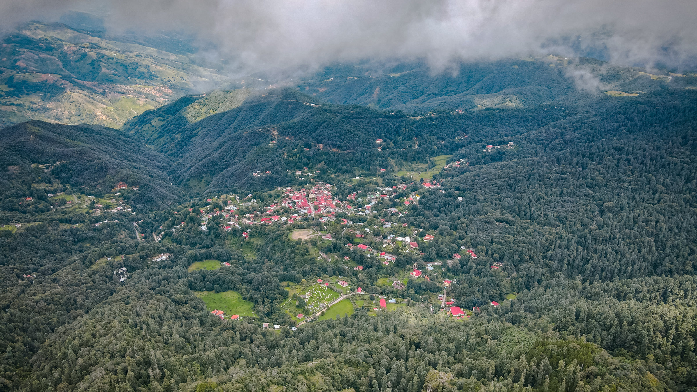 Vista aérea de Mineral del Chico rodeado de bosque y neblina